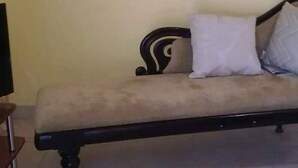 Uma sala de estar com sofá, televisão e um quadro na parede.