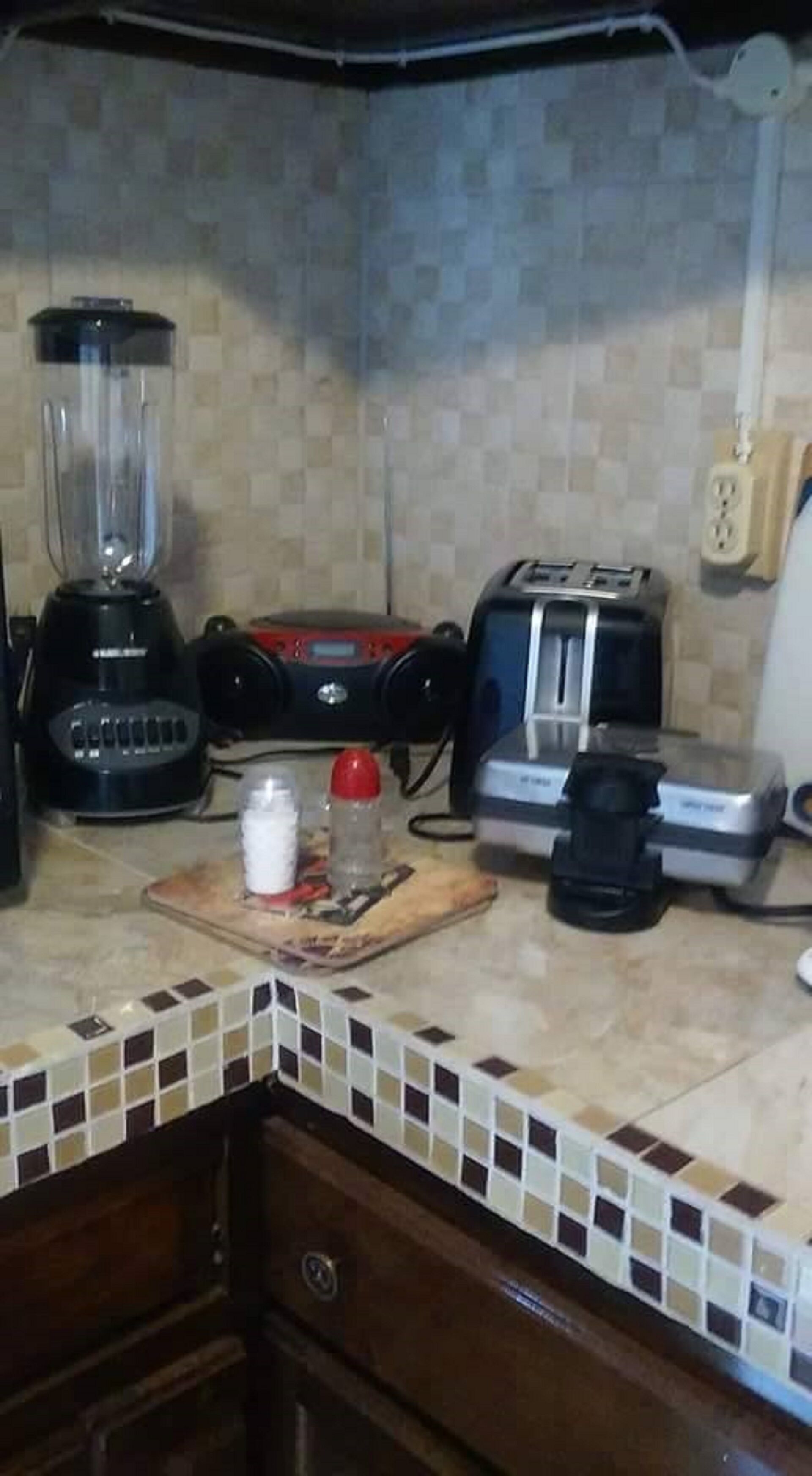 Ett kök med en mixer, brödrost och kaffebryggare på bänkskivan.