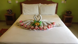 Un lit agrémenté d’une décoration en forme de cœur, réalisée avec des serviettes, des fleurs et un motif de cygne.