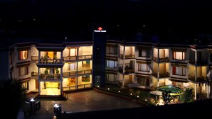 A multi-story hotel with a well-lit entrance and outdoor seating area. - Hotel Nalanda Ladakh (Leh)