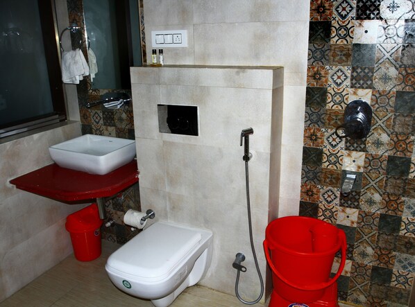A compact bathroom with a white sink, toilet, and shower. - Hotel Nalanda Ladakh (Leh)