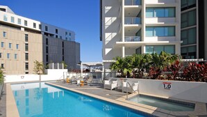 Une piscine dotée de chaises longues et d’un panneau indiquant la profondeur de la zone spa.