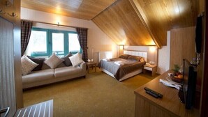 A cozy room with a bed, a sofa, a desk, and a window with curtains. - Hotel Camkar (Sarikamis)