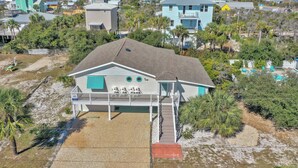 A coastal house with a balcony, surrounded by palm trees and a sandy beach. - Single Level Home on Cape San Blas, Pet Friendly with Great Views - Cape Haus (Cape San Blas)