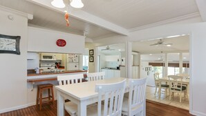 A spacious kitchen with white cabinetry, a wooden countertop, and a dining area with white chairs and a table. - Single Level Home on Cape San Blas, Pet Friendly with Great Views - Cape Haus (Cape San Blas)