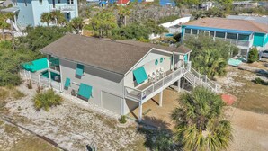 A beachfront property with a two-story house, a covered patio, and a view of the ocean. - Single Level Home on Cape San Blas, Pet Friendly with Great Views - Cape Haus (Cape San Blas)