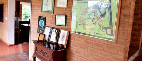 A hallway with a brick wall, a map, and framed certificates.