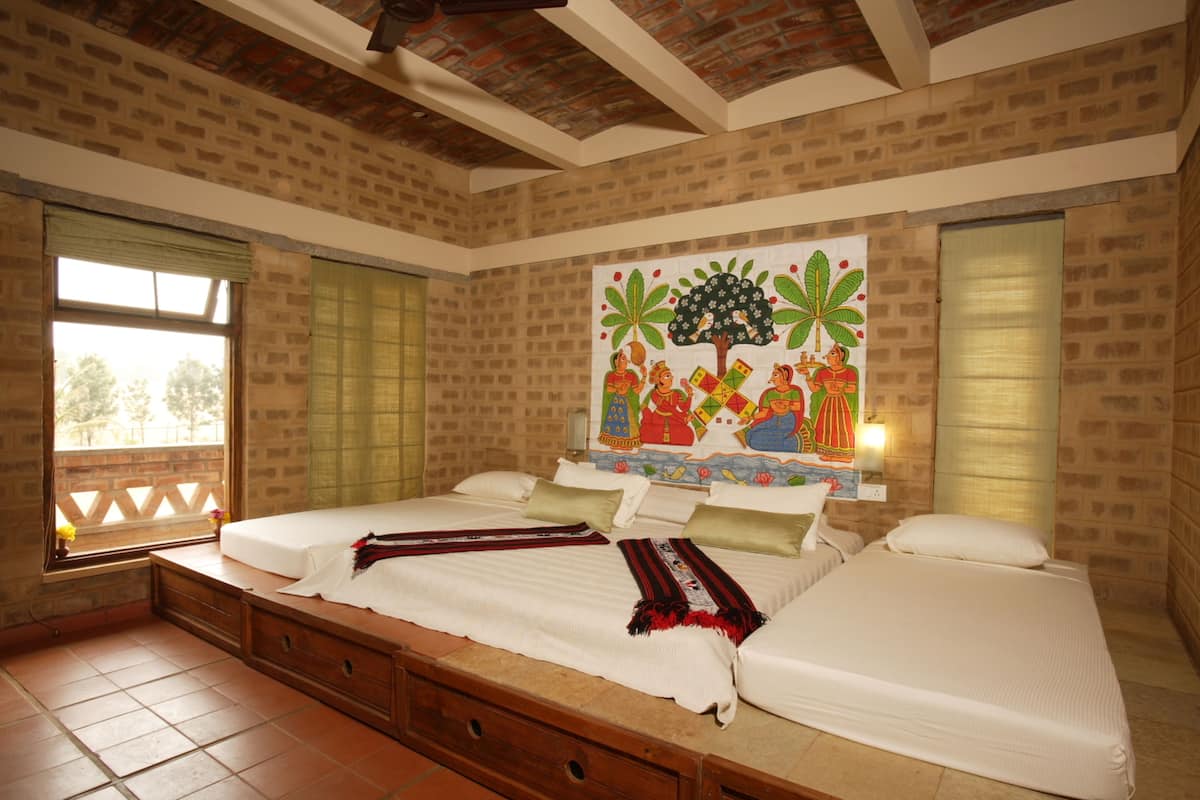 A bedroom with a large bed, a window with a view, and a mural on the wall.