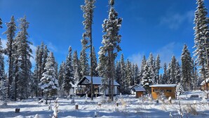 Un paysage enneigé avec un chalet comprenant plusieurs cabanes et un grand bâtiment central.