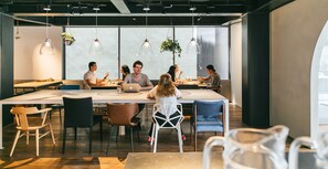 A modern meeting room with a long table, chairs, and hanging pendant lights. - Imu Hotel Kyoto (Kyoto)