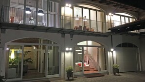 A two-story building with a balcony, large glass doors, and a staircase leading to the upper floor. - At the Court of Bertoli SPA - Lena House (Canale)