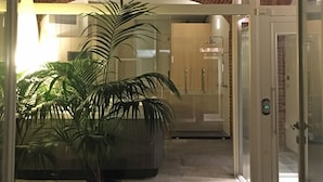 A hallway with a brick ceiling, potted plants, and a glass door leading to a room. - At the Court of Bertoli SPA - Lena House (Canale)