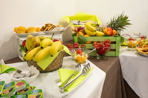 Freshly prepared breakfast options are served on a beautifully set table with a variety of fruits and baked goods.