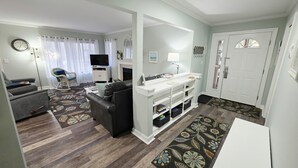 Un salon avec un canapé, un téléviseur et une cheminée.