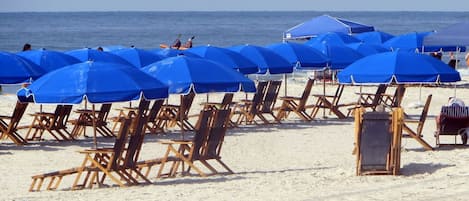 Una playa cerca, sillas reclinables de playa, toallas de playa
