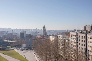 Un paisaje urbano con una torre destacada en la lejanía, rodeado de edificios modernos y un cielo despejado.
