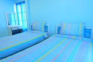 A bedroom with two beds, a bedside table, a mirror, and a window with curtains. - Baan Fa La Mai Resort (Tak)
