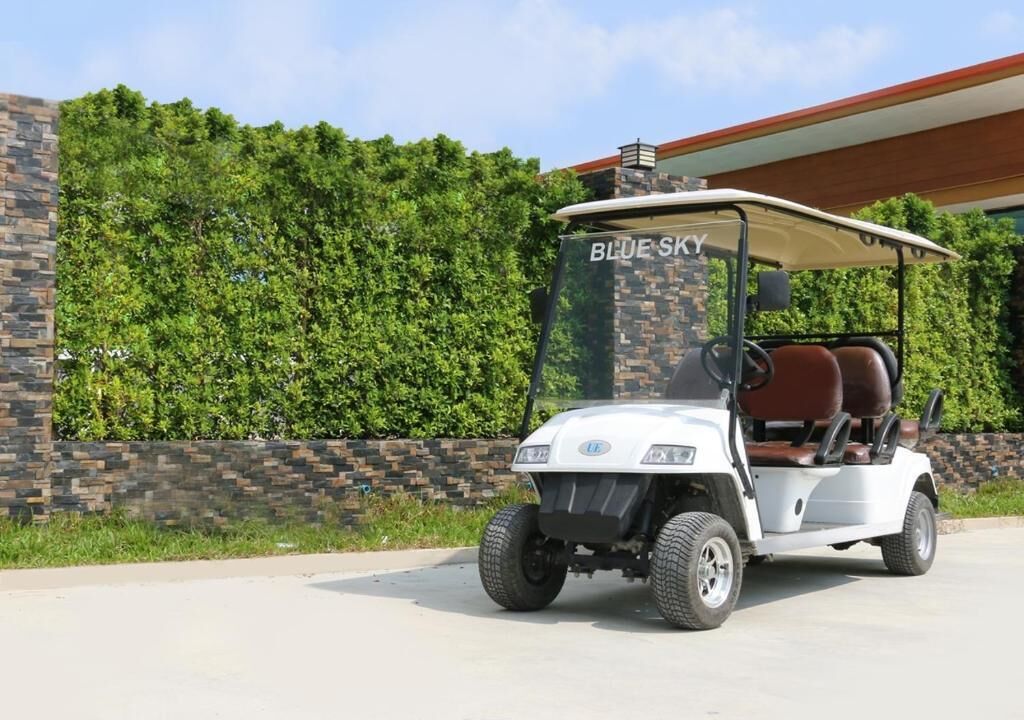 A golf cart parked in front of a building with a sign that reads "BLUE SKY."
