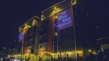 A multi-story hotel with a prominent sign reading "Blue Sky Residence."