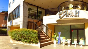 A hotel with a sign reading "Ark 21" and a staircase leading to the entrance. - Koga Ark Hotel (Koga)