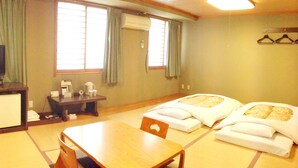 A hotel room with a wooden table, two beds with white linens, a desk with a telephone, and a TV. - Koga Ark Hotel (Koga)