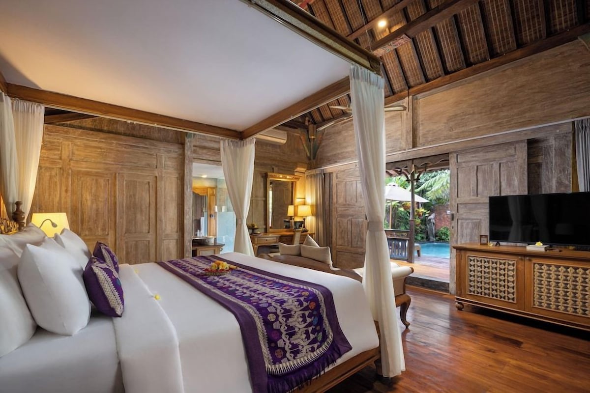 Un dormitorio amplio con una cama grande, televisión y vistas al exterior.