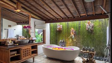 Relax in a spacious bathroom with a bathtub, vanity, and shower area.