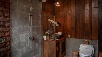 A bathroom with a shower, a sink, a toilet, and a mirror.