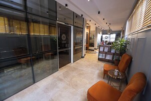 Un interior moderno con paredes de vidrio, una recepción y zonas de estar.