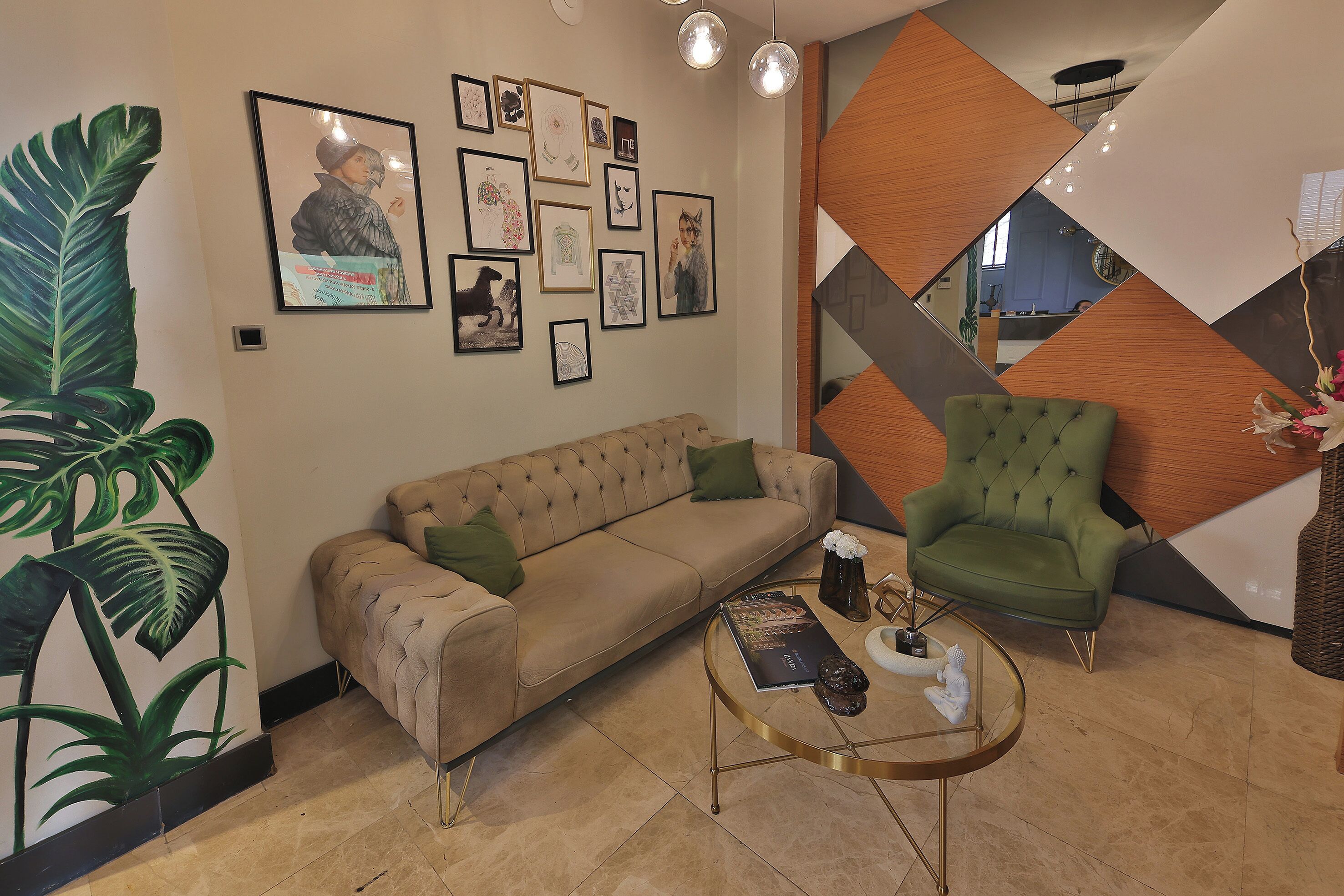 A modern lobby with a beige sofa, a green armchair, and a coffee table.