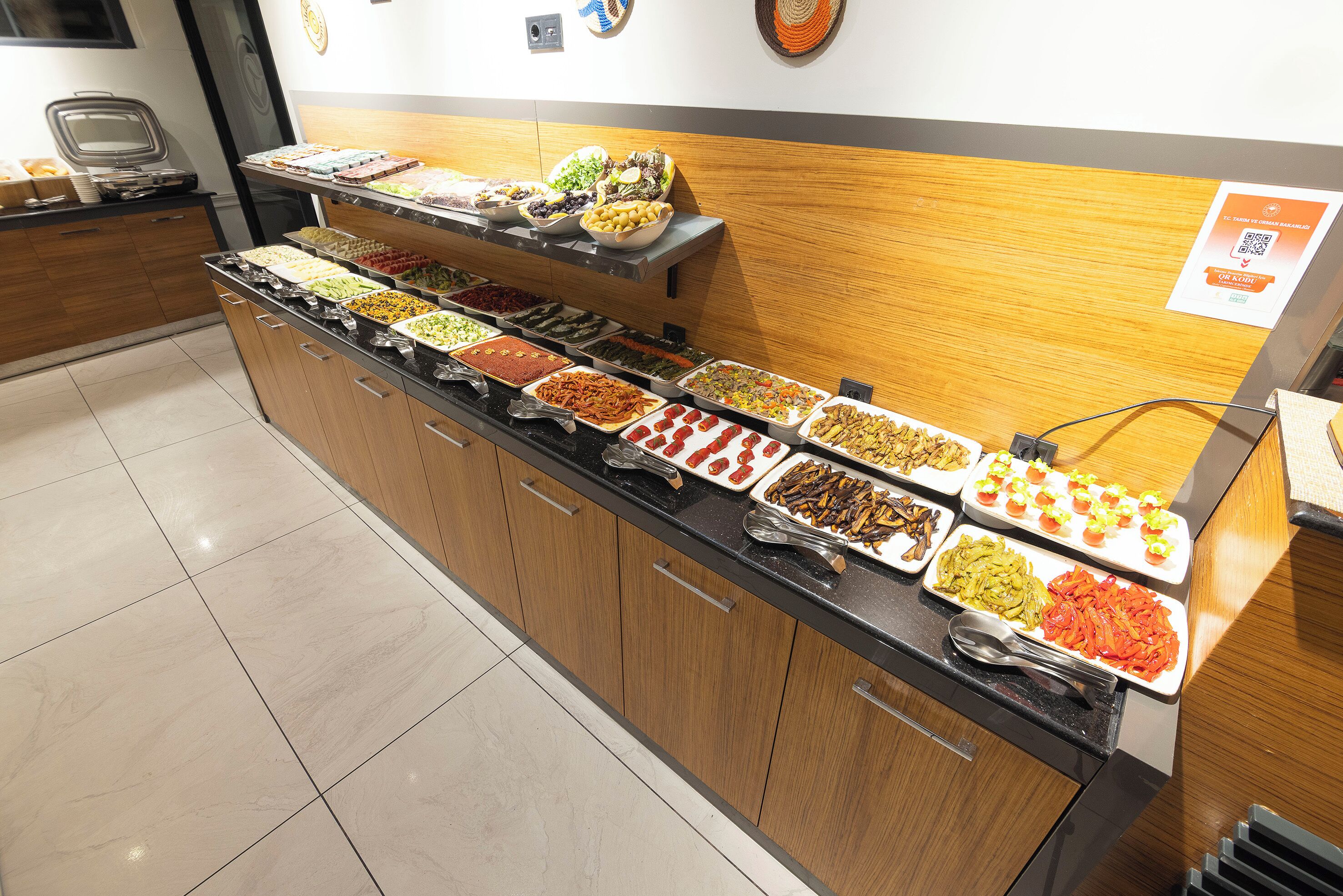 Buffet com várias estações de comida e balcão de madeira.