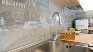 A kitchen with a stainless steel sink, a wooden countertop, and a microwave.