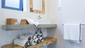 Een badkamer met een houten wastafel, een witte wasbak en een handdoekhouder.