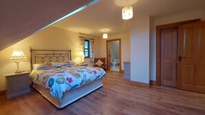 Une chambre à coucher avec un lit, des tables de chevet, une chaise, une porte et une fenêtre.