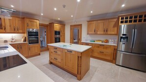 Une cuisine moderne avec des meubles en bois, des appareils en acier inoxydable et un îlot central.