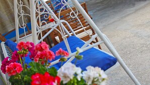 Une chaise à armature métallique avec un coussin bleu, une chaise en bois avec un coussin bleu, et une chaise à armature métallique avec un siège en bois.