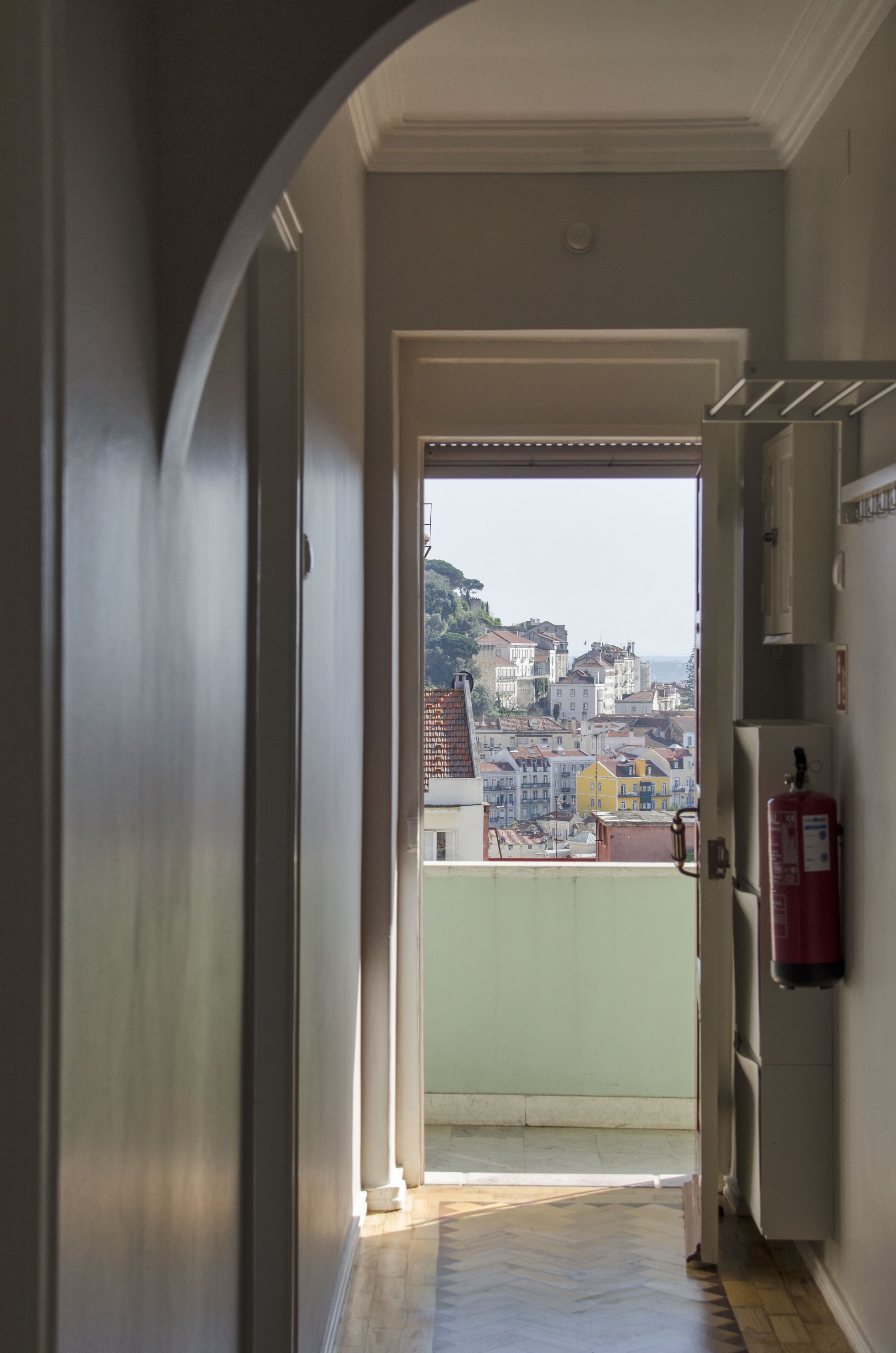 Ein Flur, der zu einem Balkon mit Blick auf die Stadt führt.