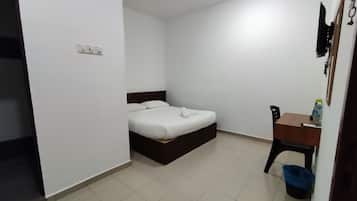 Un dormitorio con cama, escritorio y silla.