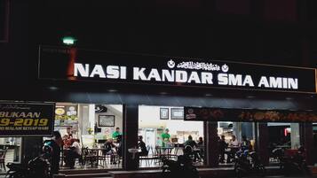 A restaurant named "NASI KANDAR SMA AMIN" with outdoor seating and a signboard advertising a promotion.