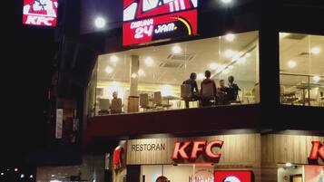 A KFC restaurant with a prominent sign and a '24 JAM' advertisement.