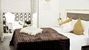 A hotel room with a large bed, a small table with a lamp, and a chair. - Relais Inn Lucca (Lucca)