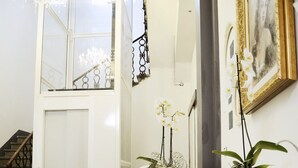 A white desk with a chair, a potted plant, and a framed picture on the wall. - Relais Inn Lucca (Lucca)