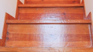 Una escalera de madera con barandilla y una lámpara en la parte superior.