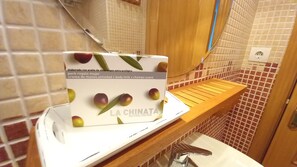 A bathroom with a white sink, a mirror, and a box labeled 'LA CHINATA' on the countertop.