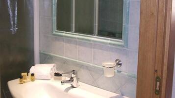 Un baño con un lavamanos blanco, un espejo y un inodoro.