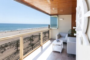 A balcony with a view of the beach and ocean.