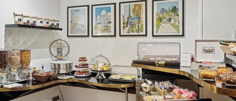 A buffet area with various food items, a coffee machine, and artwork on the wall.