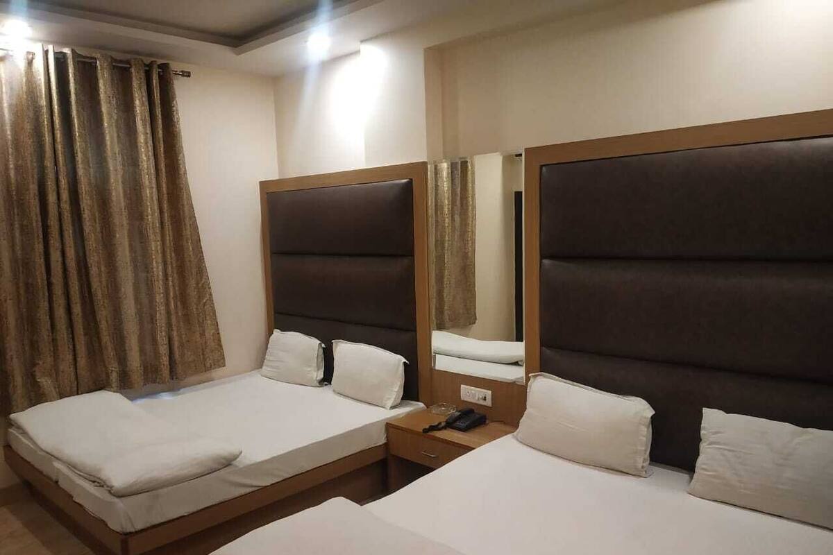 Ein Hotelzimmer mit zwei Betten, einem Nachttisch und einem Spiegel.