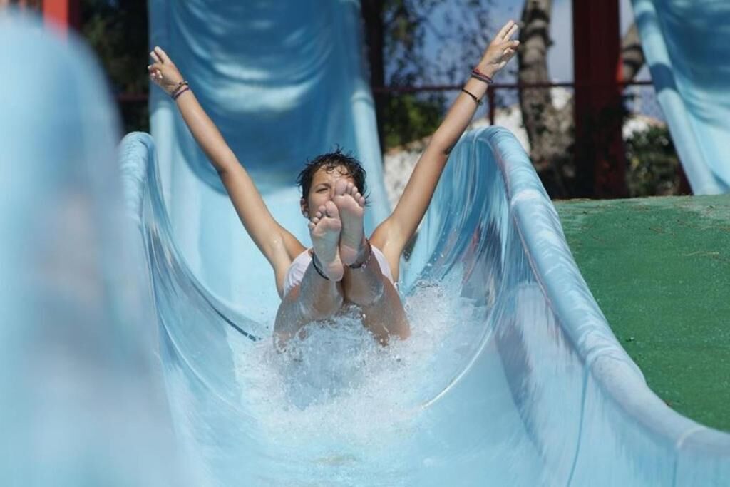 Una persona deslizándose por un tobogán de agua.