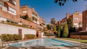 A residential building with a swimming pool, brick facades, and a clear sky. - Spectacular duplex near Barcelona and beach (Tiana)